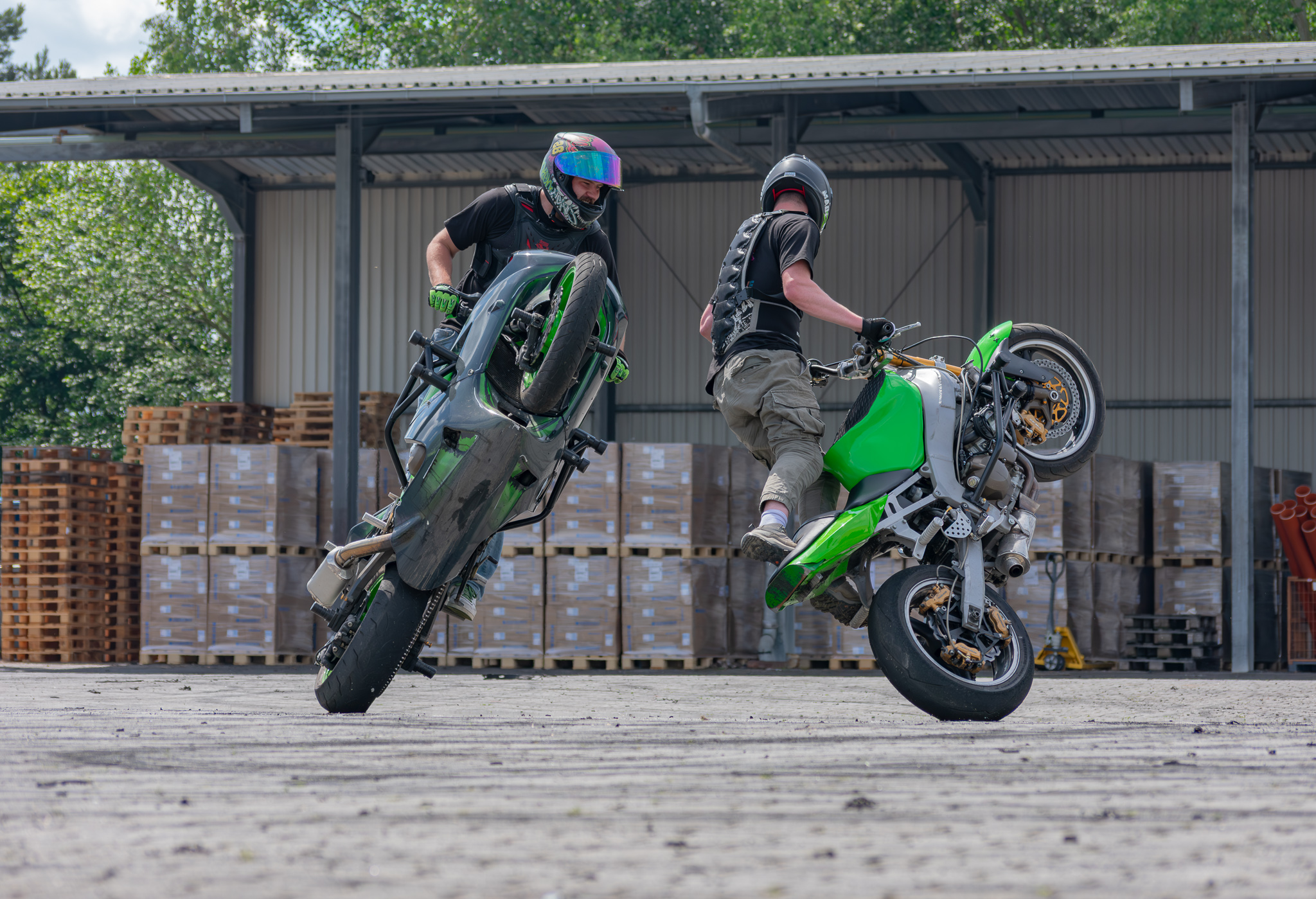 Zwei Broken Head Fahrer auf grünen Motorrädern bei einer Stuntshow